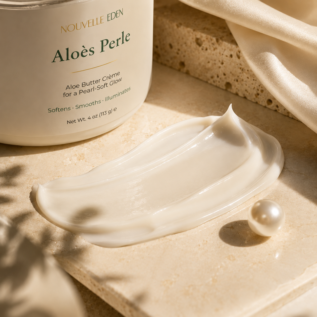 Nouvelle Eden Aloes Perle cream with a pearl on a beige surface